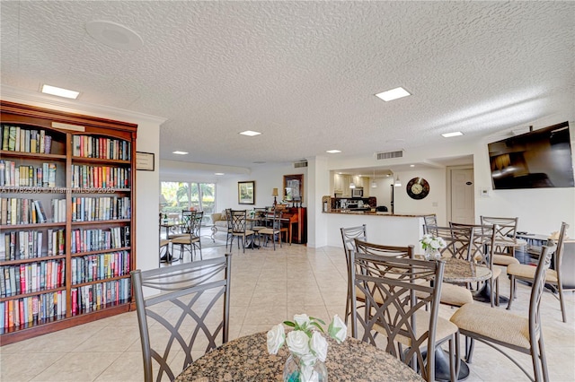 dining room with light tile patterned floors, visible vents, and a textured ceiling