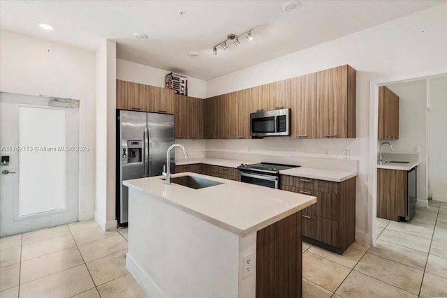 kitchen featuring light tile patterned flooring, stainless steel appliances, modern cabinets, and a sink