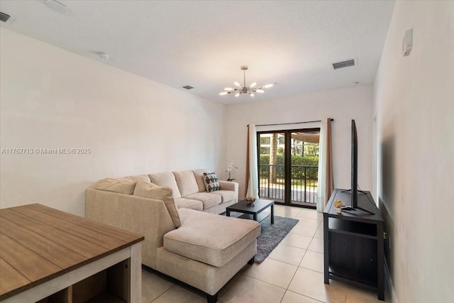 living room with light tile patterned floors, visible vents, and a chandelier