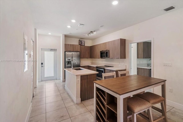 kitchen featuring visible vents, an island with sink, light countertops, appliances with stainless steel finishes, and modern cabinets