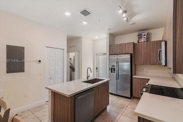 kitchen with light countertops, electric panel, light tile patterned flooring, stainless steel appliances, and a sink