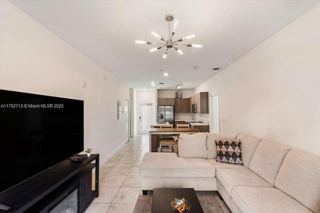 living area featuring light tile patterned floors, baseboards, a notable chandelier, and recessed lighting