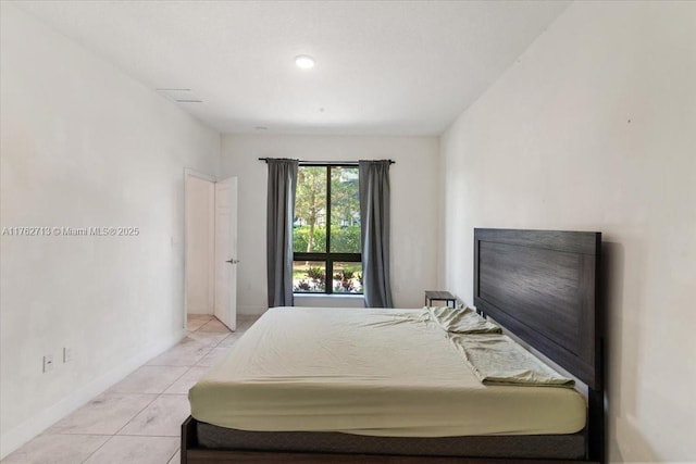 bedroom with light tile patterned floors and baseboards