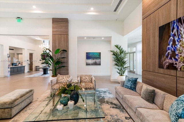 living room featuring recessed lighting, baseboards, a high ceiling, and a raised ceiling