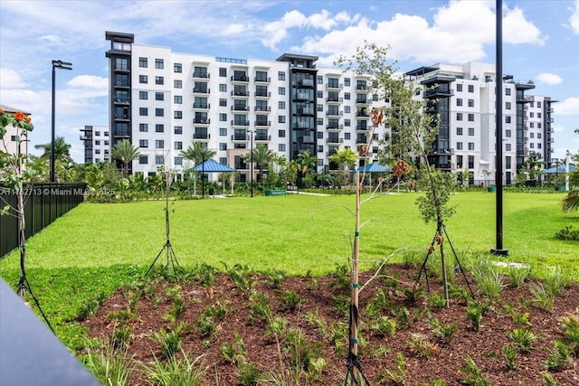 view of home's community with a lawn and fence