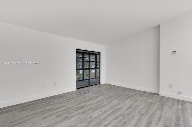 unfurnished room with wood finished floors and baseboards