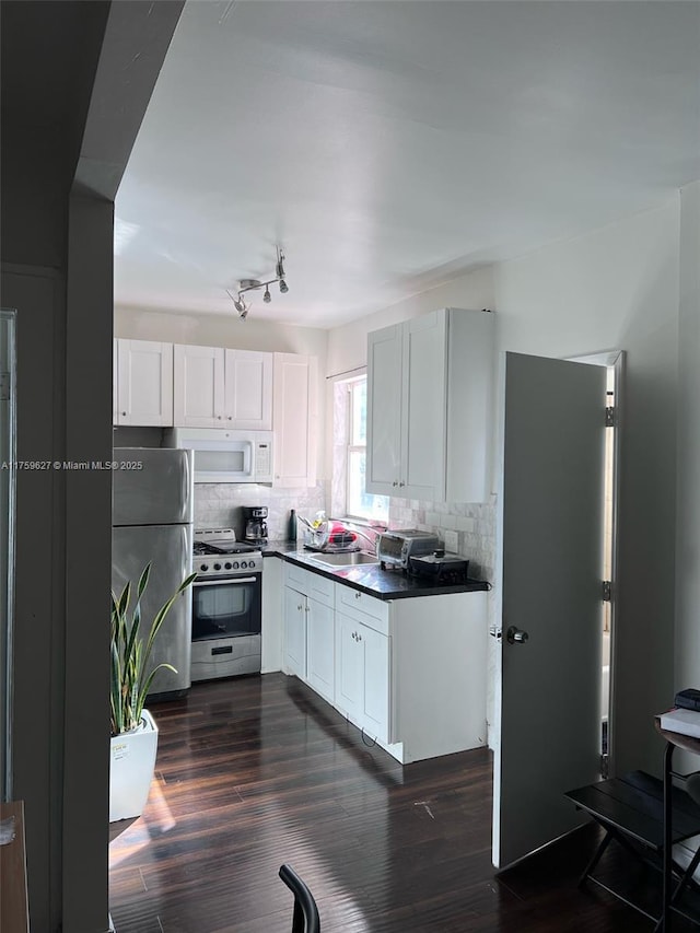 kitchen with backsplash, stainless steel appliances, dark wood-type flooring, and dark countertops