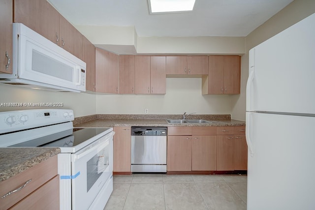 kitchen with white appliances, light tile patterned floors, and a sink