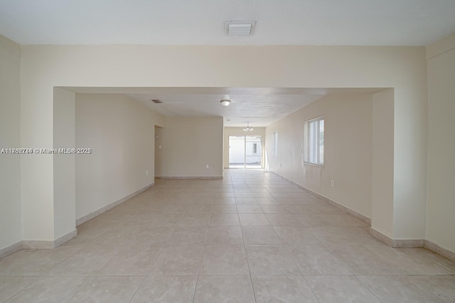 unfurnished room with light tile patterned floors, visible vents, baseboards, and a notable chandelier