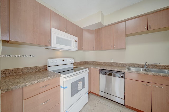 kitchen featuring light brown cabinets, light countertops, light tile patterned flooring, white appliances, and a sink