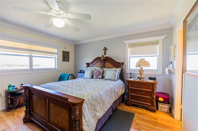 bedroom featuring ceiling fan, a textured ceiling, crown molding, and light wood-style floors