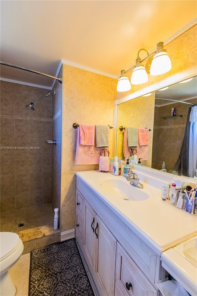 full bathroom with tile patterned flooring, crown molding, toilet, a tile shower, and vanity