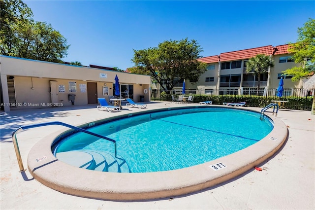 pool with a patio and fence