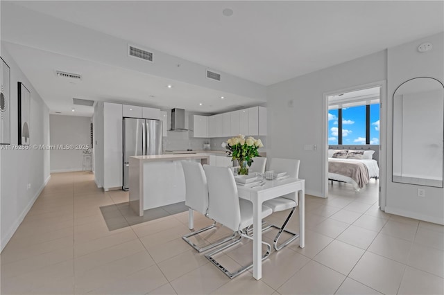 dining area featuring light tile patterned flooring, visible vents, and baseboards