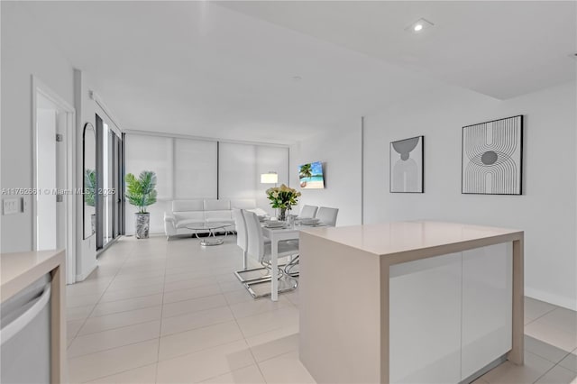 kitchen with light tile patterned floors, a wall of windows, recessed lighting, and light countertops