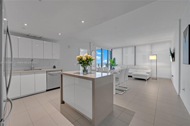 kitchen with freestanding refrigerator, a sink, white cabinets, dishwasher, and modern cabinets