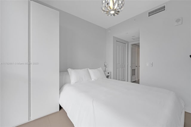 tiled bedroom with visible vents and a chandelier