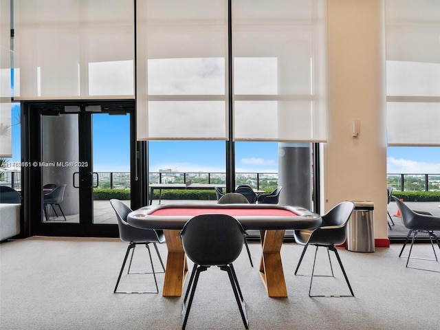 dining area featuring a high ceiling and carpet