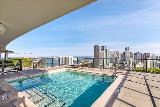 view of swimming pool with a city view and a water view