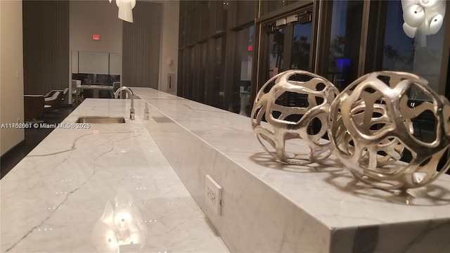 interior space with light stone counters and a sink