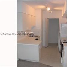 3231 Sabal Palm Mnr Unit 101, Davie, FL 33024 - kitchen featuring a peninsula, stove, and light countertops