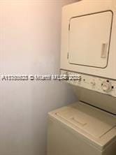 washroom with stacked washer / dryer and laundry area