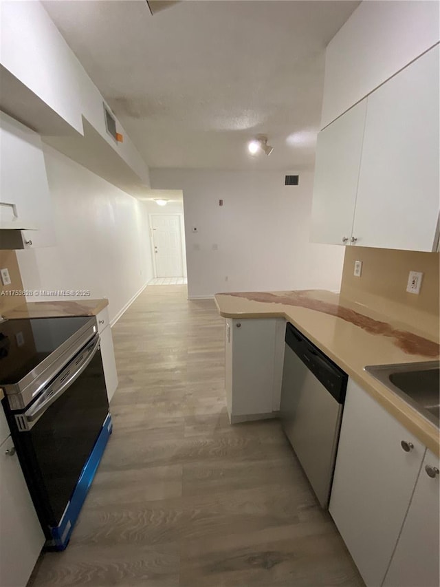 3231 Sabal Palm Mnr Unit 101, Davie, FL 33024 - kitchen featuring dishwasher, electric range, white cabinets, light wood-style flooring, and a peninsula