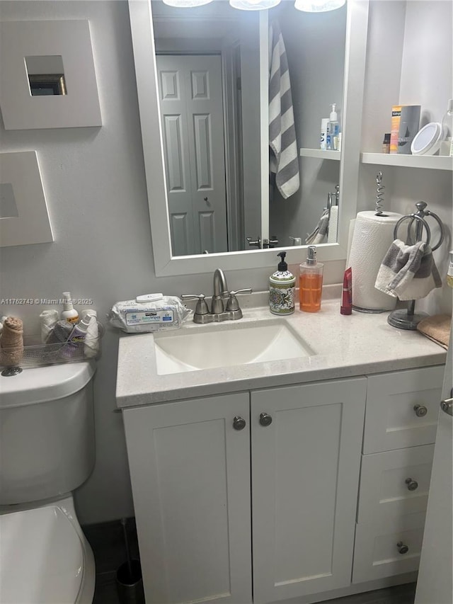 half bathroom featuring vanity and toilet