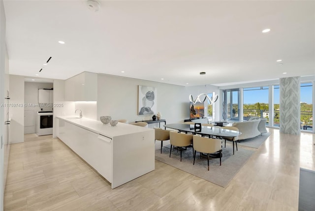 kitchen with recessed lighting, a sink, light countertops, white cabinets, and modern cabinets