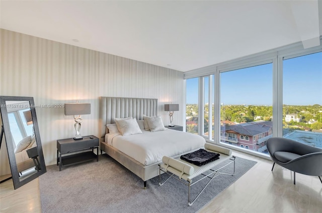 bedroom featuring floor to ceiling windows and wallpapered walls