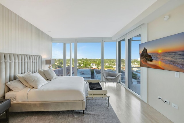 bedroom featuring expansive windows and access to outside