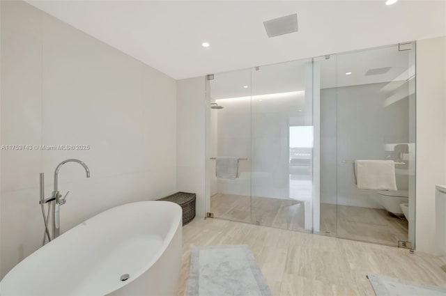 bathroom featuring visible vents, a soaking tub, a stall shower, and toilet