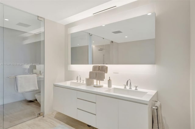 full bathroom featuring an enclosed shower, double vanity, toilet, and a sink