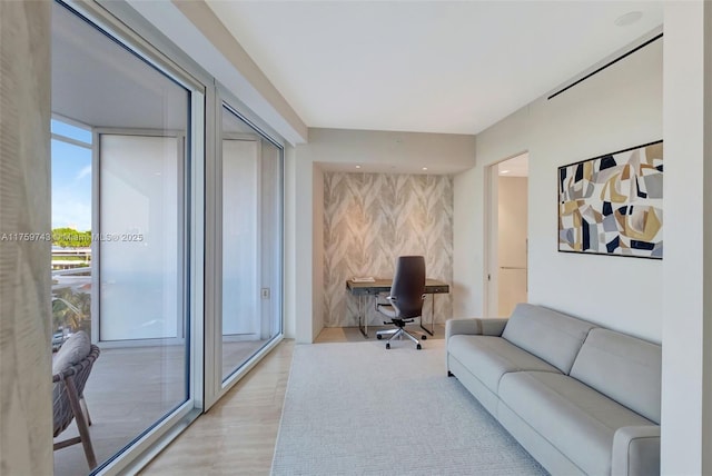 office area featuring an accent wall and wood finished floors