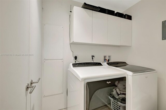 clothes washing area featuring cabinet space and washing machine and dryer