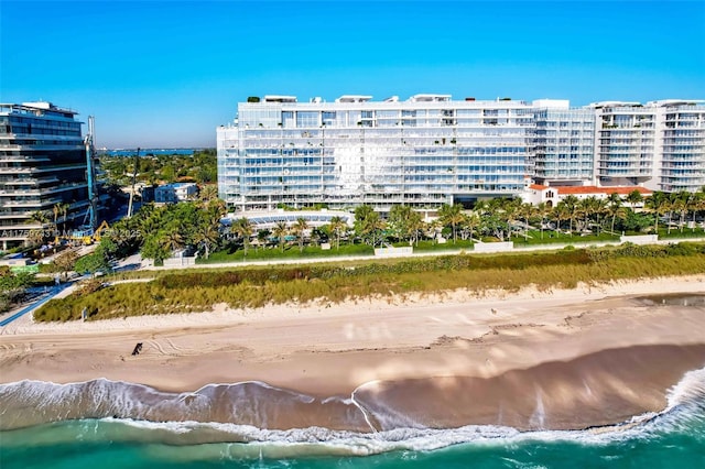 view of building exterior featuring a city view, a beach view, and a water view