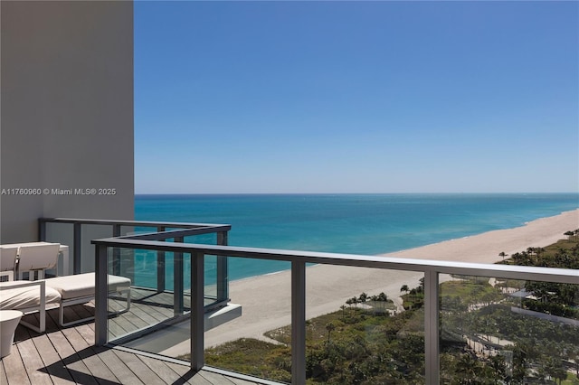 balcony featuring a view of the beach and a water view