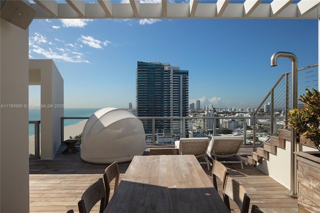 exterior space with outdoor dining area, a view of city, and a water view