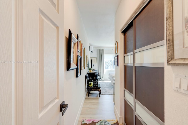 corridor featuring baseboards and light wood-style floors