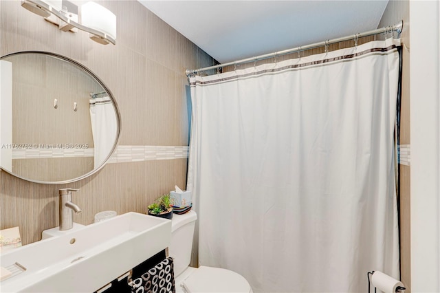 full bathroom featuring a shower with shower curtain, toilet, and a sink