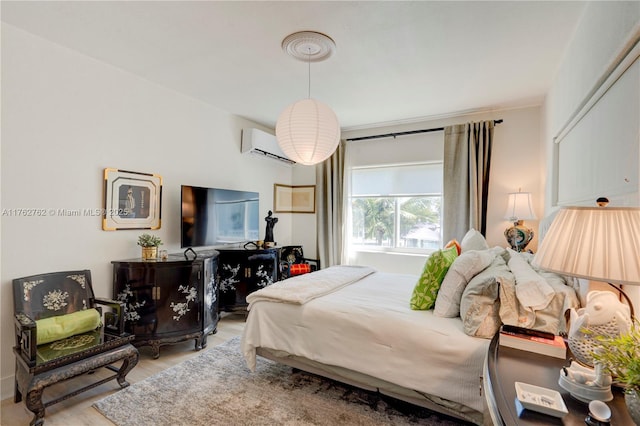 bedroom featuring a wall mounted air conditioner and wood finished floors