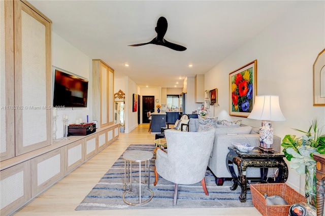 living area with light wood finished floors, recessed lighting, baseboards, and a ceiling fan