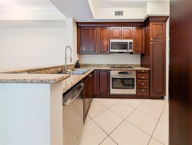 kitchen with visible vents, a sink, a peninsula, appliances with stainless steel finishes, and light tile patterned flooring