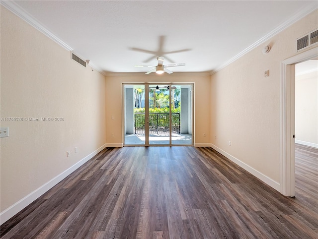 spare room featuring visible vents, baseboards, ornamental molding, and dark wood-style flooring