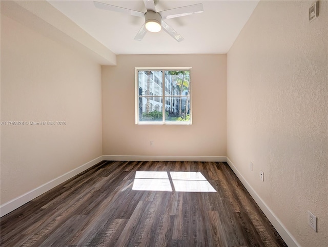 spare room featuring baseboards, wood finished floors, and a ceiling fan