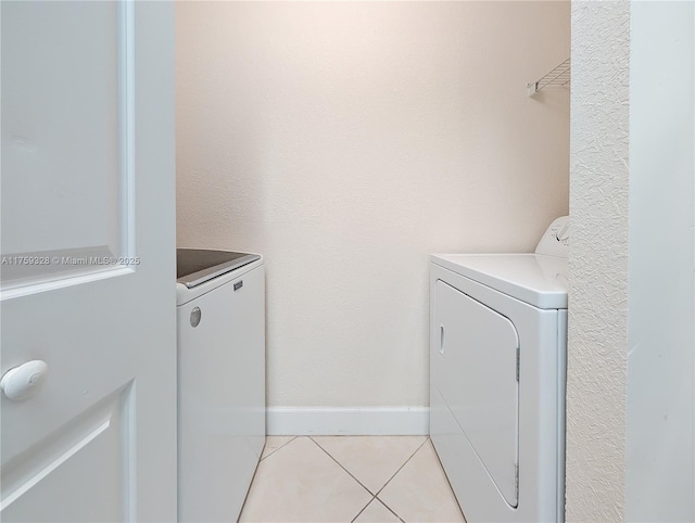 laundry room with light tile patterned floors, baseboards, laundry area, and washing machine and clothes dryer