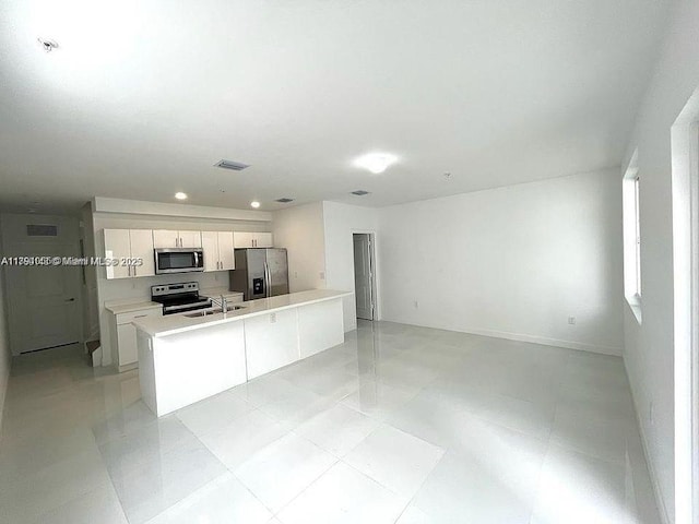 kitchen with white cabinets, appliances with stainless steel finishes, light countertops, and a sink