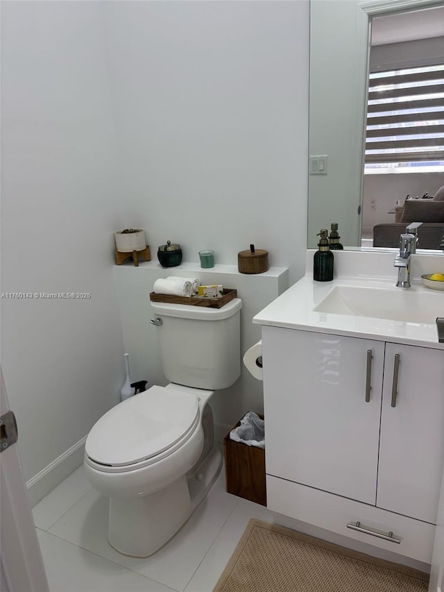 bathroom with toilet, vanity, and tile patterned flooring