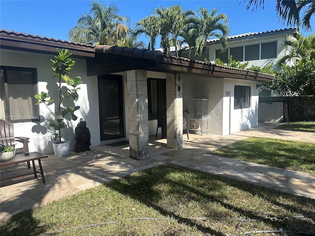 rear view of property with stucco siding and a patio