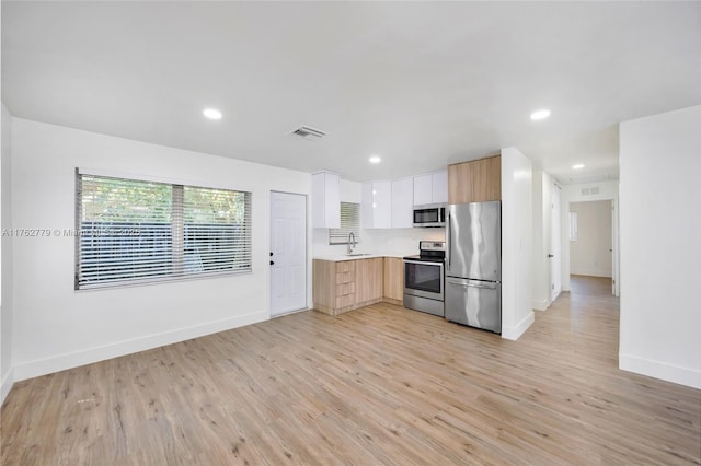 kitchen with visible vents, light wood finished floors, light countertops, appliances with stainless steel finishes, and modern cabinets